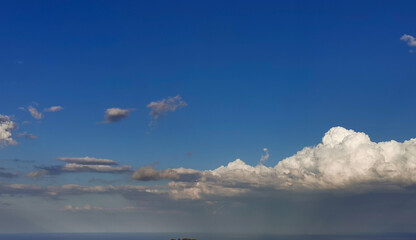 Obraz na płótnie Canvas Sopra le grandi nuvole bianche il cielo azzurro e il sole sotto la tempesta