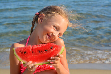 Cute little girl with slice of fresh juicy watermelon on beach, space for text