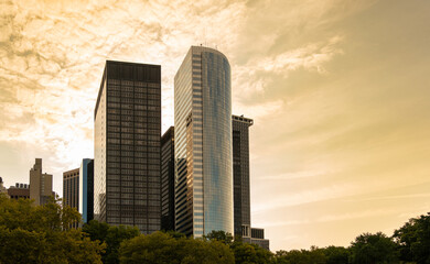 Obraz premium Skyscrapers of lower Manhattan against a golden-hued cloudy sky