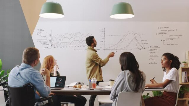 Business people in meeting, disability man with question and manager doing presentation of statistics, data and graphs. Creative software development team in a workshop with mentor or coach in office
