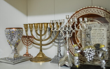 A Kiddush cup with golden hanukkah menorah and Hanukkiah on the shelf. Celebrating Jewish festivals