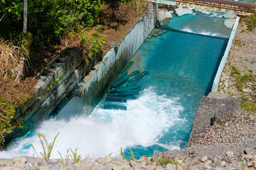 Unusual turquoise polluted water flowing in river waterway at Panguna Mine in Bougainville, Papua New Guinea