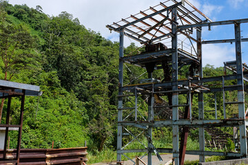 Abandoned steelworks machinery structure amongst the jungle in Panguna mine town on tropical island...