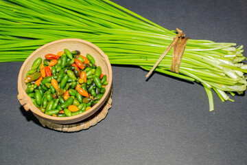 Chinese chives or garlic chives, along with chiltepin chili. Ingredients for the preparation of chiltepin chilli sauce