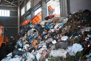 A garbage truck unloads household waste in the receiving chamber of a waste sorting plant