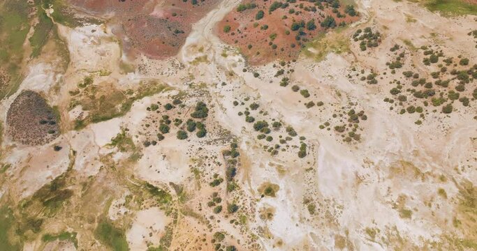Dry rocky landscape with scarce greenery. Travertine Hot Springs scenery from drone footage at daytime.
