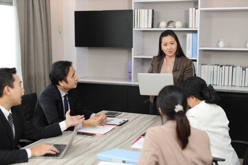 Collaborative process of professional businesspeople going over on new project together, using computer presentation and brainstorming ideas, coworker and working together at office meeting concept