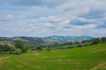 Fototapeta Gorgeous view of the Gran Sasso mountain range in Abruzzo, Italy with green fields under a blue sky obraz