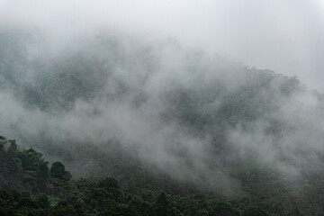 Mountain range with visible silhouettes through the morning colorful fog.