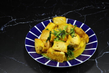 Traditional fried and stirred crispy tofu with soy sauce and pepper serving on the plate. Famous vegetarian food menu in Asia restaurant. 