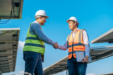 Two engineers are shaking hands at solar farm