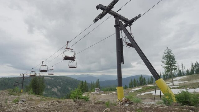 Slow motion wide of chair lift at ski resort in summer in Idaho on overcast day