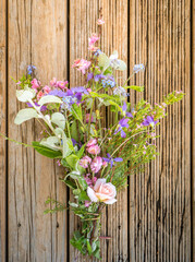 Hand Picked Bouquet of Spring Flowers with Selective Focus on Rustic Wood