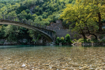 view of  voidomatis river with the famous clear waters and the  bridge as background  in epirus Greece.