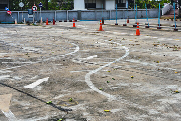Driving test and training area with simulate test for driving license. Driving school practice traffic area with pole signs and orange cones and road signs for safety on concrete road. Selective focus