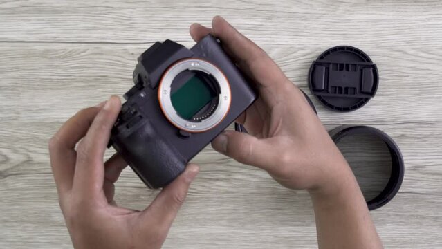 professional photographer checking and exposed full frame sensor on mirrorless camera side by side with large lens