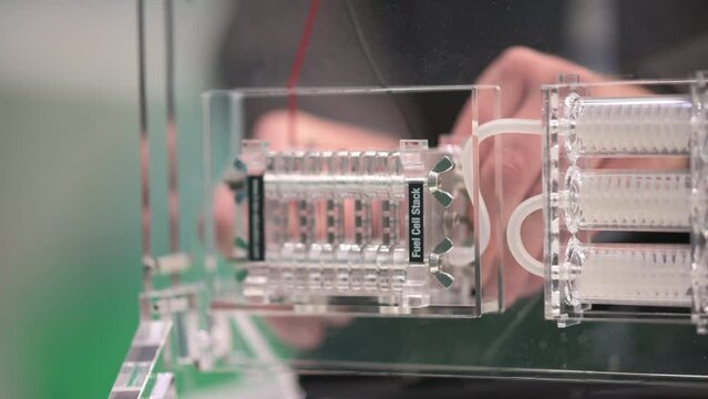 Hands connecting a fuel cell stack to generate electricity from hydrogen and air (oxygen)