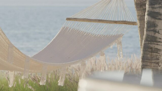 White Hammock Swaying In Breeze With Beach View In Mexico In Slow Motion