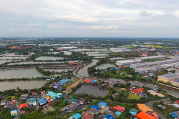 Aerial top view of industry factory in urban city town. Inventory import and export business commercial, Automobile and automotive industry distribution logistic transport with lake and river.