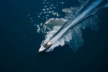 Boat fast moving aerial view. Luxurious boat fast movement on dark water. Luxurious Red White...