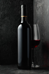 Bottle and glass of red wine.
