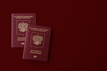 Two Russian international passports on a burgundy background.