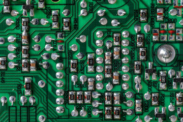 Old printed circuit board background. Vintage circuit board with soldering trace. Backside brown...