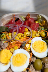 Fototapeta na wymiar Salad not mixed close-up, egg, corn, tomato - fresh vegetables with home delivery.