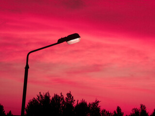 Street lamp on the background of sunset. A glowing street lamp. Close-up
