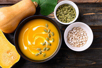 Butternut squash pumpkin soup in bowl on wooden background, Homemade food in autumn season, Table top view