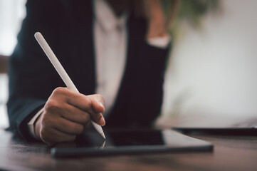Business Woman using a digital pencil on iPad. hand holds stylus and puts an electronic signature...