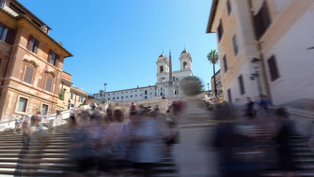 Spanish steps in Rome, Italy, between Trinita dei Monti church and Piazza di Spagna, bustling with people. Crowds of tourists on the stairs, enjoying the sunny day - hyper lapse.