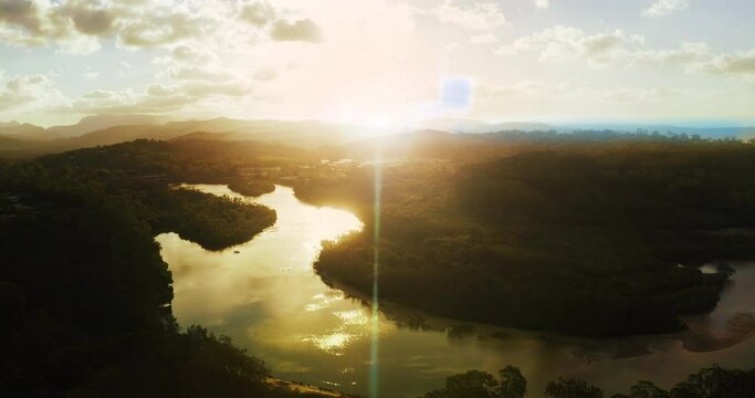 Amazon forest and sky drone with sunset flare on river in peaceful rainforest nature environment. Aerial view of tropical jungle landscape and ecosystem in ecuador with dreamy evening clouds.