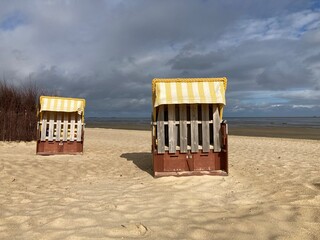 Einsame Strandkörbe am Strand der Nordsee in Cuxhaven  - obrazy, fototapety, plakaty