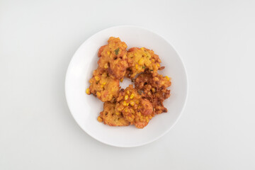 close up of fried corn fritter or in Indonesia called Perkedel Jagung or Bakwan Jagung with shrimp inside isolated on white background