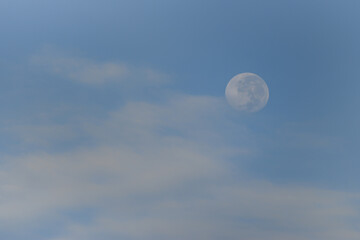 Morning moon in blue sky with clouds.
