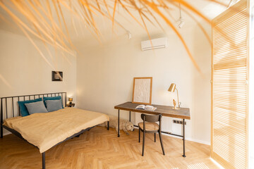 Fototapeta premium Interior of studio apartment with cozy bedroom and working place in beige tones