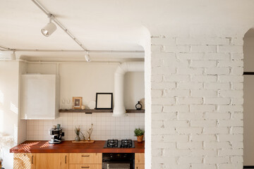 Beautiful stylish kitchen interior with decorated open shelves, wooden facades and tiled table top in white and beige tones