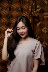 Fototapeta premium Beauty portrait of happy Asian woman face with natural skin on Indonesian Batik background.