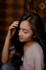 Obraz premium Beauty portrait of happy Asian woman face with natural skin on Indonesian Batik background.