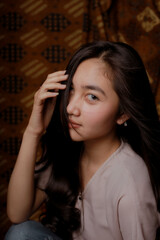 Obraz premium Beauty portrait of happy Asian woman face with natural skin on Indonesian Batik background.