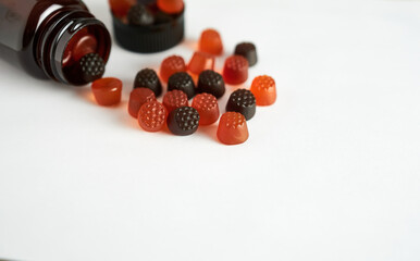 Chewable vitamins for children on a white background with a brown bottle in close-up.  Vitamin C.  