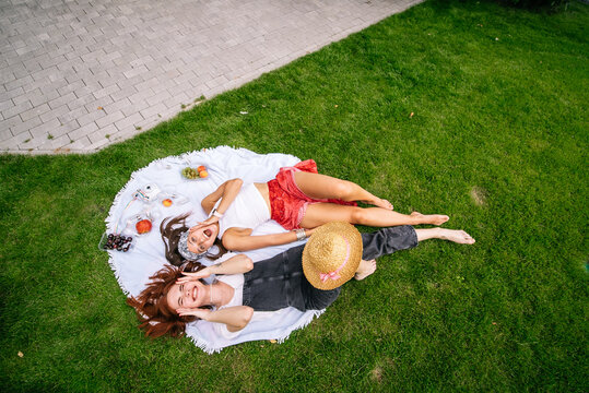 Top view, two young women lying in the park