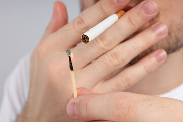 Man light a cigarette with match, close up