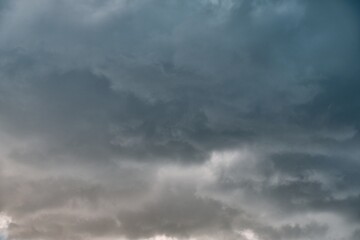 A piece of a blue sky with many clouds around. Midday cloudscape in the summer sky.