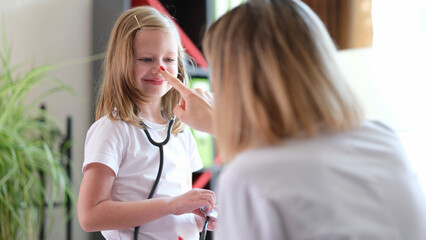 Children visit to doctor girl with stethoscope communicates with pediatrician