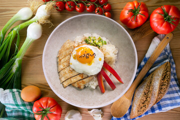 Teriyaki chicken donburi with fried egg, onion, red pepper and other vegetables. Typical Japanese dish.