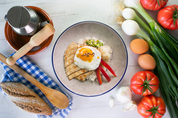 Teriyaki chicken donburi with fried egg, onion, red pepper and other vegetables. Typical Japanese dish.