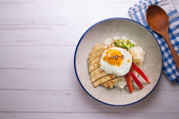 Teriyaki chicken donburi with fried egg, onion, red pepper and other vegetables. Typical Japanese dish.