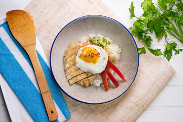 Teriyaki chicken donburi with fried egg, onion, red pepper and other vegetables. Typical Japanese dish.